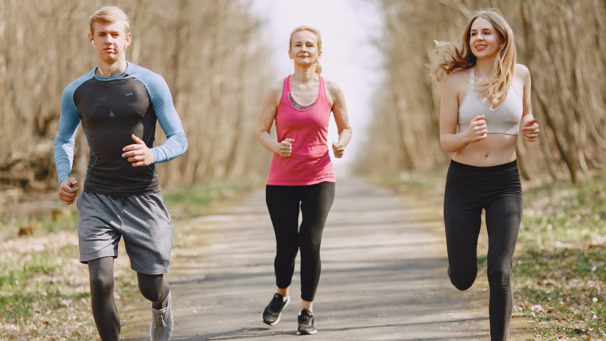 Three adults jogging on a park path, embracing a healthy and active lifestyle.